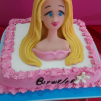 Um bolo decorado com pasta de leite em pó no tema barbie